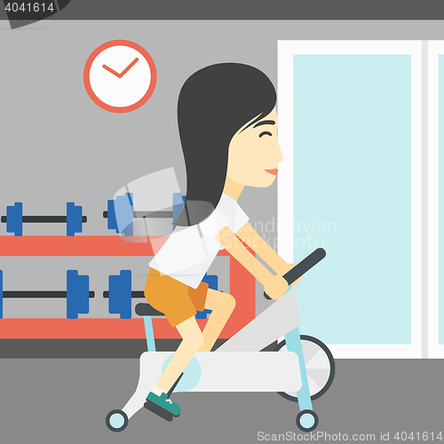 Image of Woman riding stationary bicycle.