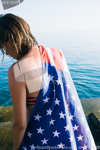 Image of Back view of wet-haired woman in american flag