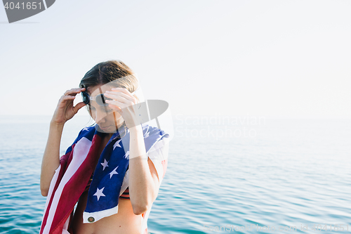 Image of Wet-haired woman putting on swimming goggles