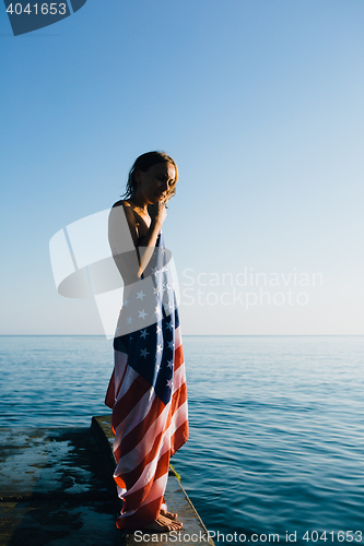 Image of Short-haired woman with american flag on pier