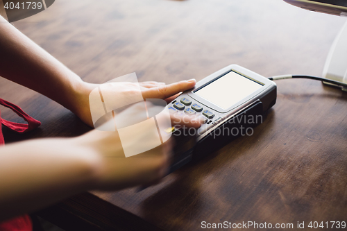 Image of Female hand inserts the credit card into the terminal