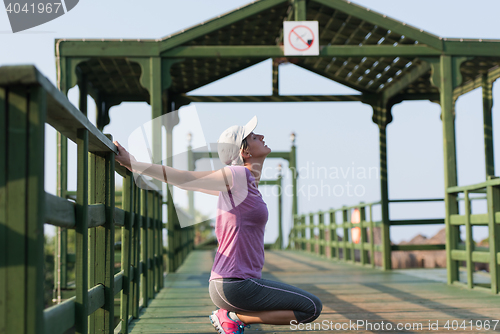 Image of woman  stretching before morning jogging