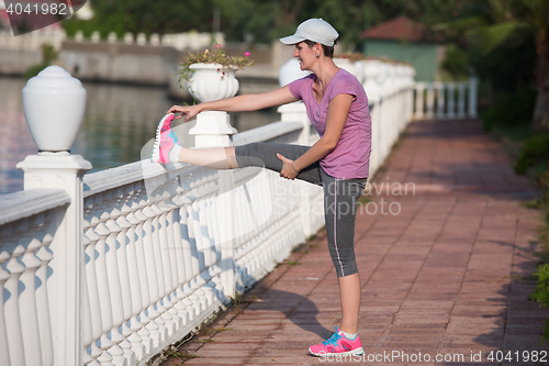 Image of woman  stretching before morning jogging