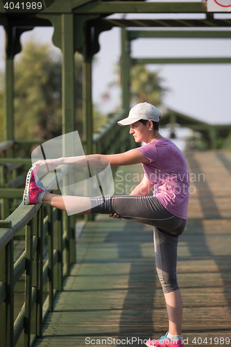 Image of woman  stretching before morning jogging