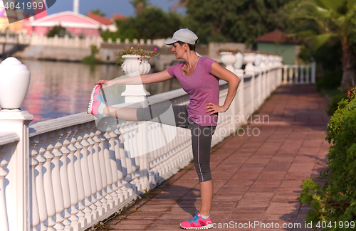 Image of woman  stretching before morning jogging