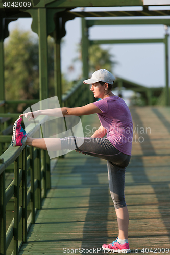 Image of woman  stretching before morning jogging