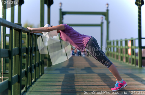 Image of woman  stretching before morning jogging