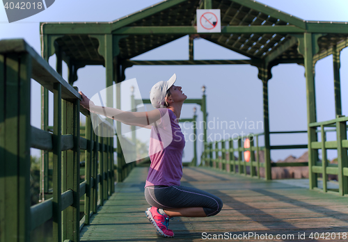 Image of woman  stretching before morning jogging