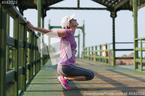 Image of woman  stretching before morning jogging