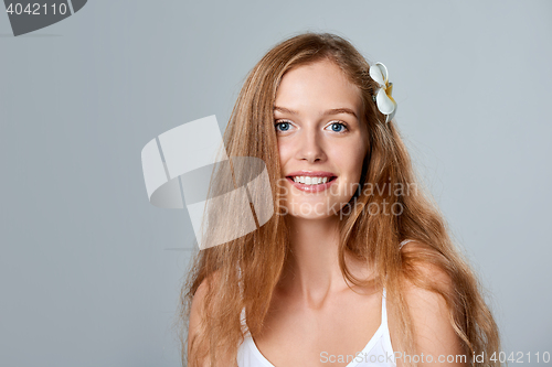 Image of Beautiful young woman with flower in hair