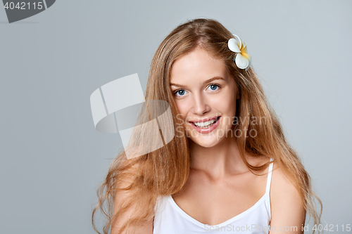 Image of Beautiful young woman with flower in hair