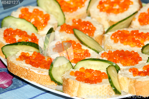 Image of sandwiches with red caviar and cucumber 