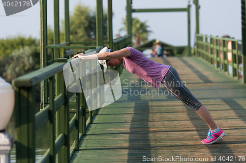 Image of woman  stretching before morning jogging