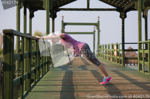 Image of woman  stretching before morning jogging