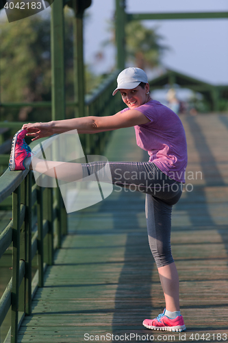 Image of woman  stretching before morning jogging