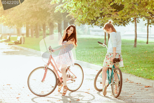 Image of The two young girls with bicycles in park