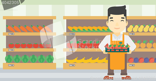 Image of Supermarket worker with box full of apples.