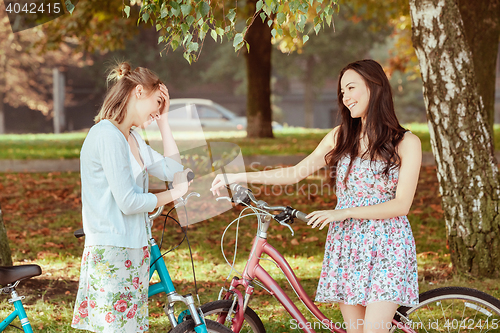 Image of The two young girls with bicycles in park