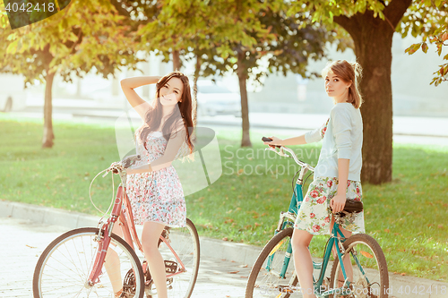 Image of The two young girls with bicycles in park