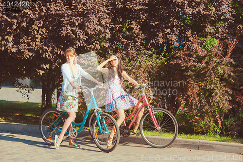 Image of The two young girls with bicycles in park