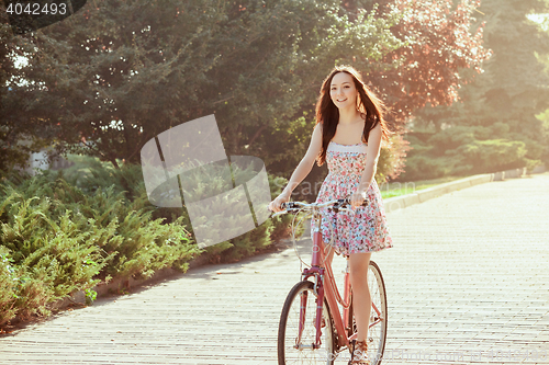 Image of The young girl with bicycle in park
