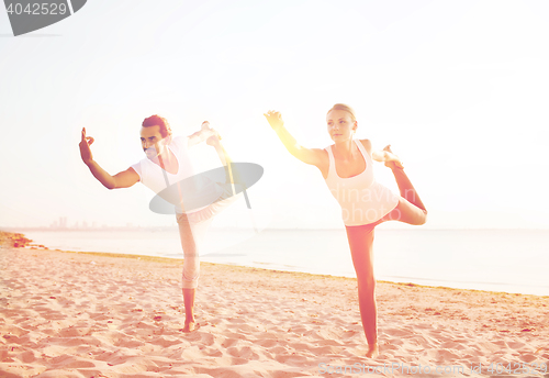 Image of couple making yoga exercises outdoors