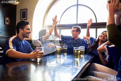 Image of football fans with beer celebrating victory at bar