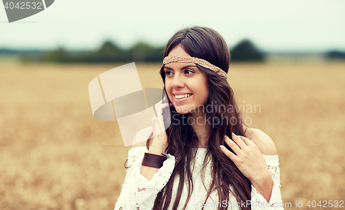 Image of smiling young hippie woman on cereal field