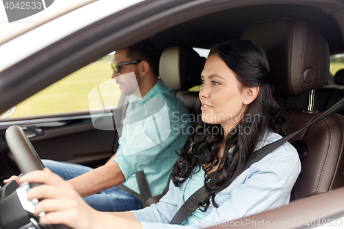 Image of happy man and woman driving in car