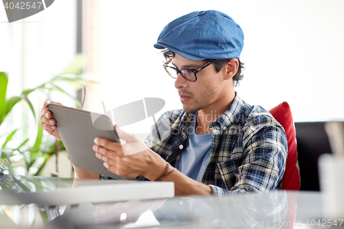 Image of man with tablet pc sitting at cafe table