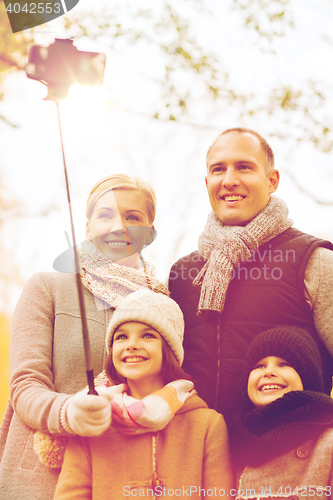 Image of happy family with smartphone and monopod in park