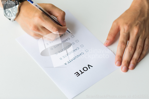 Image of close up of hands with vote or ballot on election