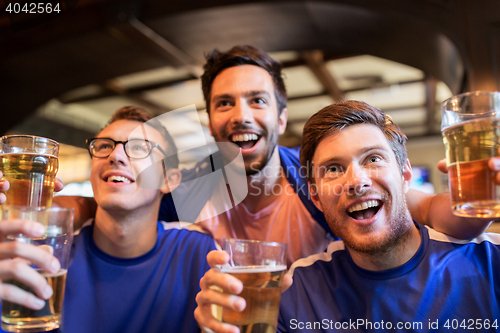 Image of football fans or friends with beer at sport bar