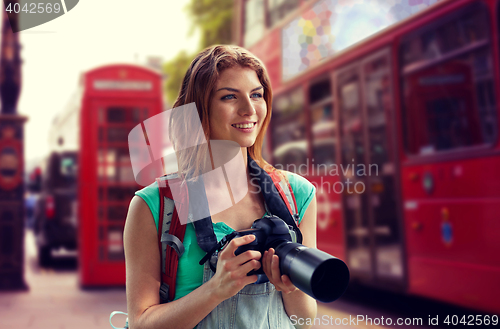 Image of woman with backpack and camera over london city