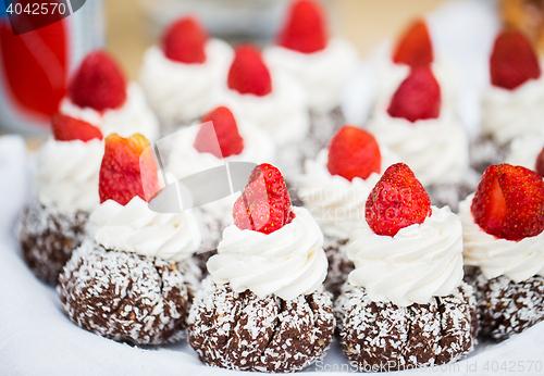 Image of close up of rum cakes with custard and strawberry