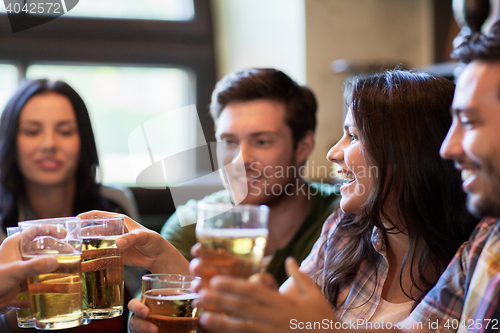 Image of happy friends drinking beer at bar or pub