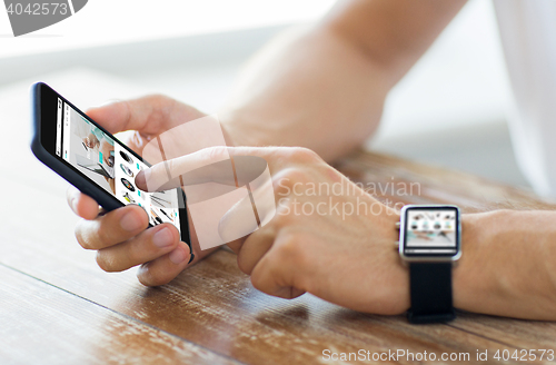 Image of close up of hands with smart phone and watch