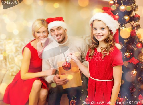 Image of smiling family decorating christmas tree