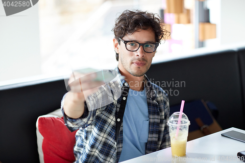 Image of happy man with cash money paying at cafe