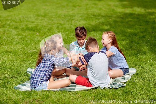 Image of group of happy kids putting hands together