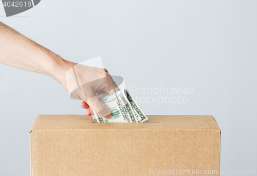 Image of man putting dollar money into donation box