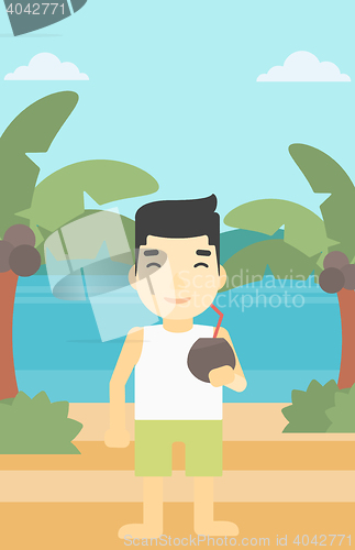 Image of Man drinking coconut cocktail on the beach.