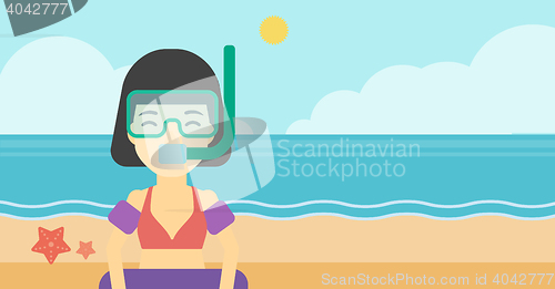 Image of Woman with snorkeling equipment on the beach.