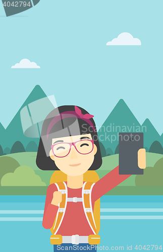 Image of Woman with backpack making selfie.