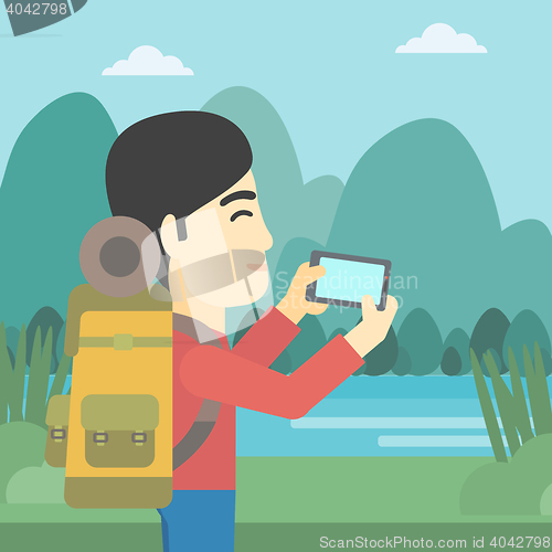 Image of Man with backpack taking photo.