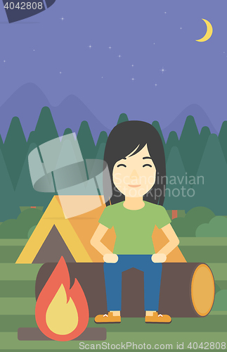 Image of Woman sitting on log in the camping.