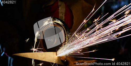 Image of Worker cutting metal with grinder. Sparks while grinding iron