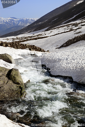 Image of Mountain river with snow bridges in spring sun day