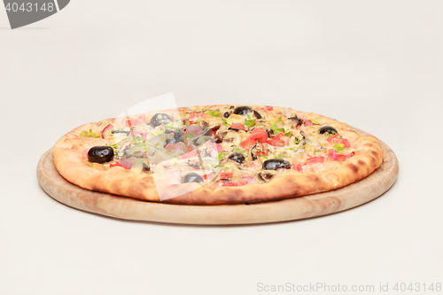 Image of Tasty pizza with vegetables, chicken and olives isolated on white