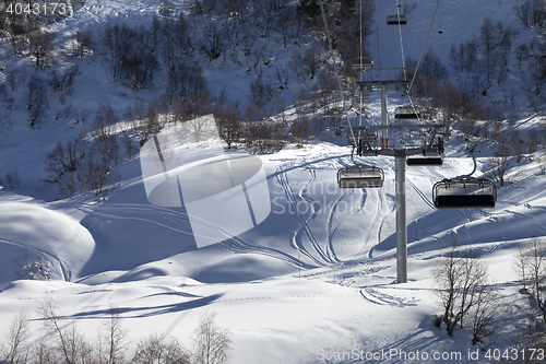 Image of Chair-lift and off-piste slope in winter day